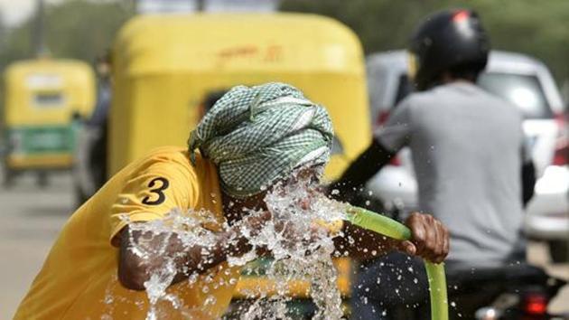 A man drinks from a water pipe along a highway on a hot summer day near Krishna Nagar metro station in New Delhi.(Biplov Bhuyan/HT PHOTO)