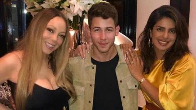 Priyanka Chopra, Nick Jonas and Mariah Carey pose together.