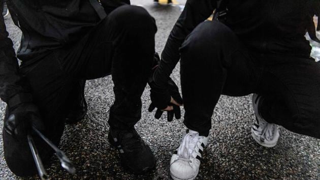 Abby (R), 19, and her boyfriend Nick, 20, (L) -- who are keeping their real names under wraps -- hold hands as they crouch down on a road, after they found each other in a shopping mall following their separation, as tear gas was being fired by police during a protest in Tsuen Wan, an area in the New Territories in Hong Kong. (Anthony Wallace / AFP) Abby (R), 19, and her boyfriend Nick, 20, (L) -- who are keeping their real names under wraps -- hold hands as they crouch down on a road, after they found each other in a shopping mall following their separation, as tear gas was being fired by police during a protest in Tsuen Wan, an area in the New Territories in Hong Kong. (Anthony Wallace / AFP)