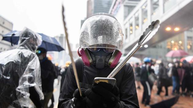 Nick holds metal cooking tongs as he types a message to his girlfriend after they were separated when police fired tear gas. For endless weeks they have fended off tear gas and run from police baton charges, an unlikely band of rebels -- labelled “rioters” by Hong Kong police and “terrorists” by China -- who have forged tight bonds over a long holiday of demonstrations. (Anthony Wallace / AFP) Nick holds metal cooking tongs as he types a message to his girlfriend after they were separated when police fired tear gas. For endless weeks they have fended off tear gas and run from police baton charges, an unlikely band of rebels -- labelled “rioters” by Hong Kong police and “terrorists” by China -- who have forged tight bonds over a long holiday of demonstrations. (Anthony Wallace / AFP)