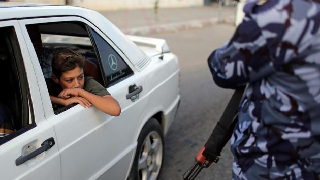 A boy looks out of a car as a member of Palestinian Hamas security forces stands guard at a checkpoint in Khan Younis in the southern Gaza Strip. (Ibraheem Abu Mustafa / REUTERS) A boy looks out of a car as a member of Palestinian Hamas security forces stands guard at a checkpoint in Khan Younis in the southern Gaza Strip. (Ibraheem Abu Mustafa / REUTERS)