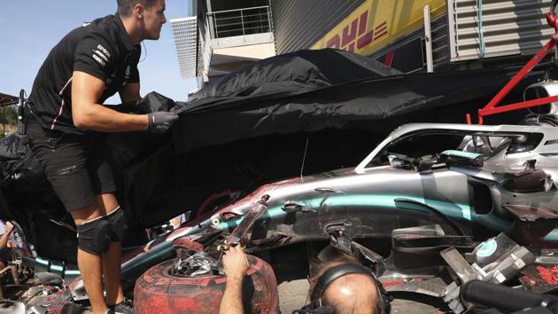 A member of the Mercedes team views the damaged car of Mercedes driver Lewis Hamilton. (AP) A member of the Mercedes team views the damaged car of Mercedes driver Lewis Hamilton. (AP)