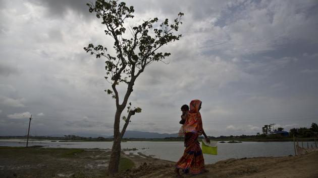 A woman walks on her way to check her name in the final NRC list at Pabhokati village. The final NRC is a supplementary list of inclusion or exclusion of those applicants whose names were not included in earlier drafts, those who faced objections on their inclusions or those who were in the earlier drafts but called for hearings that took place since July this year. (Anupam Nath / AP) A woman walks on her way to check her name in the final NRC list at Pabhokati village. The final NRC is a supplementary list of inclusion or exclusion of those applicants whose names were not included in earlier drafts, those who faced objections on their inclusions or those who were in the earlier drafts but called for hearings that took place since July this year. (Anupam Nath / AP)
