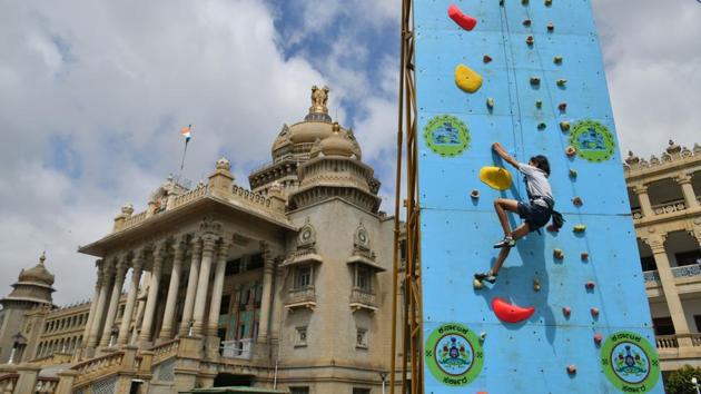 A young rock climber scales a vertical artificial wall in front of the Vidhana Soudha to mark the nationwide launch of the Fit India Movement, in Bengaluru, Karnataka. (Manjunath Kiran / AFP) 