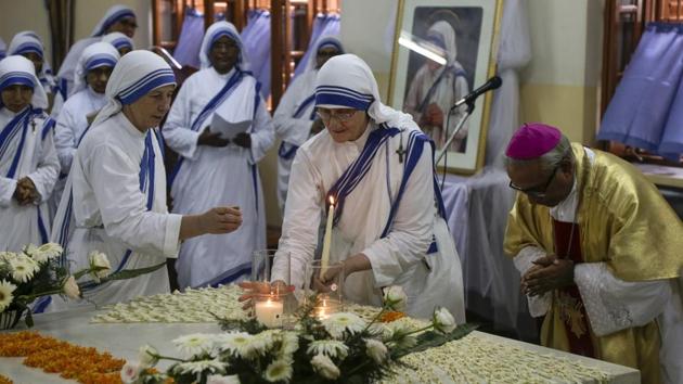 Sister Mary Prema Pierick, center, Superior General of the Missionaries of Charity, the order founded by Mother Teresa, lights a candle as Thomas D'Souza, right, Archbishop of Calcutta bows at the tomb on her birth anniversary in Kolkata, West Bengal. (Bikas Das / AP) 