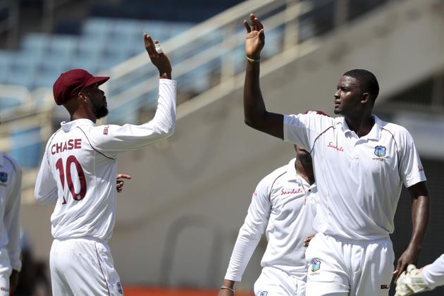 West Indies' captain Jason Holder, right, celebrates with teammate Roston Chase taking the wicket of India's KL Rahul during day one of the second Test. (AP) West Indies' captain Jason Holder, right, celebrates with teammate Roston Chase taking the wicket of India's KL Rahul during day one of the second Test. (AP)