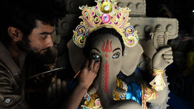 An artisan works on a sculpture of Hindu Lord Ganesh ahead of the upcoming Ganesh Chaturthi festival, at a workshop in Hyderabad, Telangana. (Noah Seelam / AFP) 