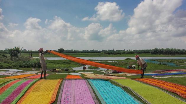 Washermen organise clothes for drying on a field, at Nadia district of West Bengal. (PTI) 