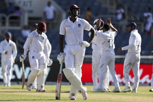 West Indies' captain Jason Holder looks up as players of India celebrate the dismissal of Shimron Hetmyer during day two of the second Test. (AP) West Indies' captain Jason Holder looks up as players of India celebrate the dismissal of Shimron Hetmyer during day two of the second Test. (AP)