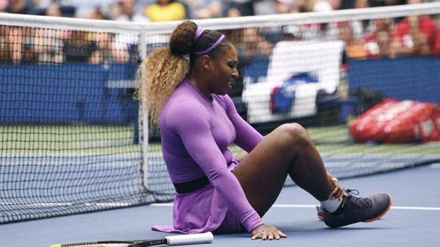 Serena Williams, of the United States, grabs her ankle after falling while chasing a return against Petra Martic, of Croatia(AP)