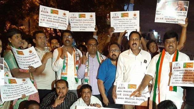 Congress workers protest against the arrest of DK Shivakumar by Enforcement Directorate (ED), near the Mahatma Gandhi statue in Bengaluru.(ANI Photo)