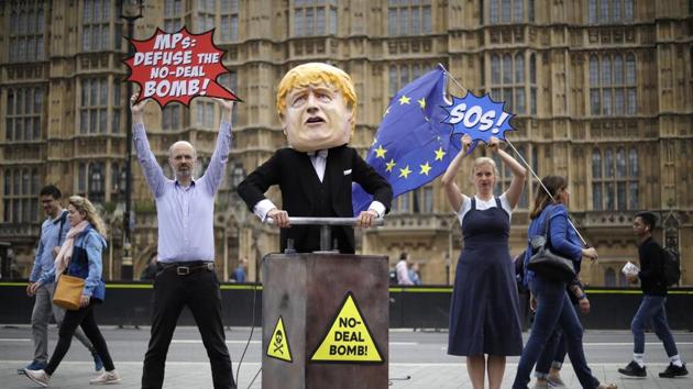 A woman walks by with an EU flag as remain campaigners hold signs next to a giant puppet depicting British Prime Minister Boris Johnson pushing a detonator on a No Deal outside Parliament Square in London. (Photo: AP) A woman walks by with an EU flag as remain campaigners hold signs next to a giant puppet depicting British Prime Minister Boris Johnson pushing a detonator on a No Deal outside Parliament Square in London. (Photo: AP)