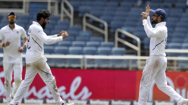 India's Ravindra Jadeja, left, celebrates with captain Virat Kohli taking the wicket of West Indies' captain Jason Holder. (AP)