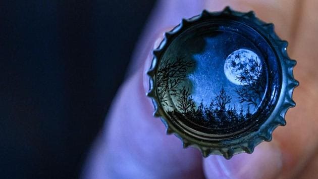 Hasan Kale paints a moon landscape on a bottle cap in Istanbul. Kale has used some 300 items and revels in the idea that any forgettable item -- from a pebble stone in the sea, to a fish bone that gets stuck in your teeth -- could become a work of art. “Imagine the noise of hundreds of seeds as you bite into a fig. Can you dream an Istanbul view on one of them?” he said, enthusiastically. (Ozan Kose / AFP)
