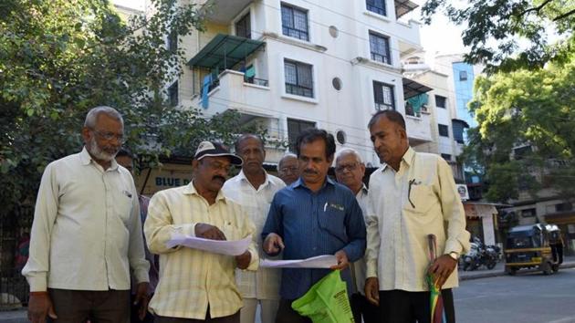 Aggrieved ex-employees of Swastik Rubber in front of what used to be land on which the factory stood. A residential society now stands there. (HT) Aggrieved ex-employees of Swastik Rubber in front of what used to be land on which the factory stood. A residential society now stands there. (HT)