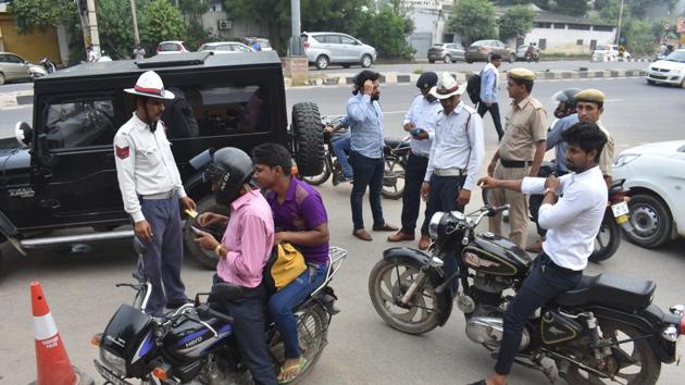 Traffic police personnel issue challans to traffic rules violators at Maharana Pratap Chowk, in Gurugram on Tuesday. (Yogesh Kumar/HT Photo) Traffic police personnel issue challans to traffic rules violators at Maharana Pratap Chowk, in Gurugram on Tuesday. (Yogesh Kumar/HT Photo)