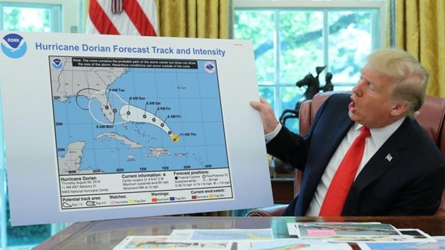 U.S. President Donald Trump holds a chart showing the original projected track of Hurricane Dorian that appears to have been extended with a black line to include parts of the Florida panhandle and of the state of Alabama during a status report meeting on the hurricane in the Oval Office of the White House in Washington, US. (Reuters Photo)