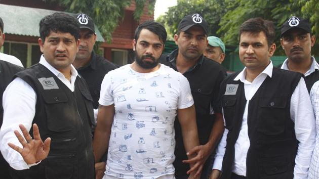 The Special Task Force (STF) Haryana police with gangster Kaushal who was arrested from Indira Gandhi International Airport early morning, at Police Commissioner Office in Faridabad.(Yogendra Kumar/HT FILE PHOTO)