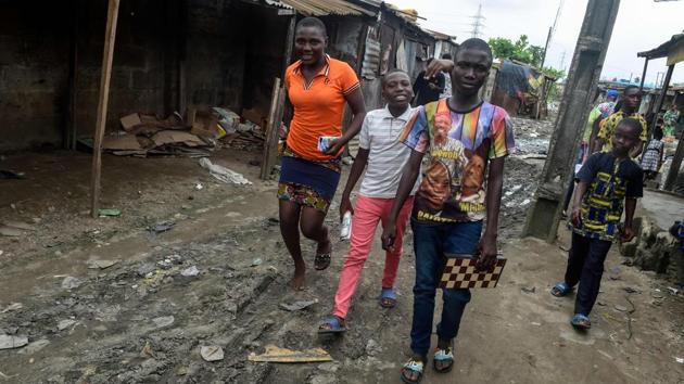 Fourteen-year-old mechanic Jamiu Ninilowo (L), holds a chessboard as he walks with classmates to attend a chess class. Dozens of matches are played simultaneously as participants as young as three master a game often considered out of reach for the masses in Africa’s most populous country. The goal of the club is to provide a space to play and learn the game for the young inhabitants of the slum, many of whom are not in school and work to support their families. (Pius Utomi Ekpei/ AFP) Fourteen-year-old mechanic Jamiu Ninilowo (L), holds a chessboard as he walks with classmates to attend a chess class. Dozens of matches are played simultaneously as participants as young as three master a game often considered out of reach for the masses in Africa’s most populous country. The goal of the club is to provide a space to play and learn the game for the young inhabitants of the slum, many of whom are not in school and work to support their families. (Pius Utomi Ekpei/ AFP)