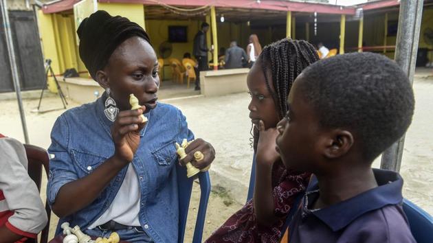 Chess teacher Omiwale Mistura (L) conducts a tutorial during a chess class. Held beneath a makeshift tent in the courtyard of a local bar, in less than a year the programme has already drawn an enthusiastic following. The youngest children sing rhymes about chess to help them master the rules, as the older ones settle down into intense games. They use mobile phone apps to time their moves and record the matches in notepads to review their mistakes and successes later. (Pius Utomi Ekpei/ AFP) Chess teacher Omiwale Mistura (L) conducts a tutorial during a chess class. Held beneath a makeshift tent in the courtyard of a local bar, in less than a year the programme has already drawn an enthusiastic following. The youngest children sing rhymes about chess to help them master the rules, as the older ones settle down into intense games. They use mobile phone apps to time their moves and record the matches in notepads to review their mistakes and successes later. (Pius Utomi Ekpei/ AFP)