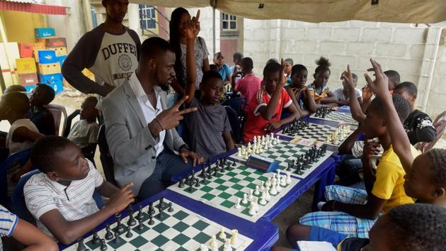 Chess consultant and player Tunde Onakoya seen with children during a chess class. Onakoya says that chess has lagged behind in part due to an image problem. “But it’s how you respond that makes you a champion. Don’t get down when you lose, don’t feel like you can’t do it, just concentrate and do your best.” Seasoned player Onakoya started the Chess in Slums project last September in the sprawling neighbourhood of Ikorodu, a place where residents often feel cut off from the bustle and business of the vibrant megacity around it. (Pius Utomi Ekpei/ AFP) Chess consultant and player Tunde Onakoya seen with children during a chess class. Onakoya says that chess has lagged behind in part due to an image problem. “But it’s how you respond that makes you a champion. Don’t get down when you lose, don’t feel like you can’t do it, just concentrate and do your best.” Seasoned player Onakoya started the Chess in Slums project last September in the sprawling neighbourhood of Ikorodu, a place where residents often feel cut off from the bustle and business of the vibrant megacity around it. (Pius Utomi Ekpei/ AFP)