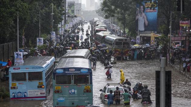 People and vehicles wade through flooded street at Dadar TT circle in Mumbai on Wednesday. (Pratik Chorge/HT Photo) People and vehicles wade through flooded street at Dadar TT circle in Mumbai on Wednesday. (Pratik Chorge/HT Photo)