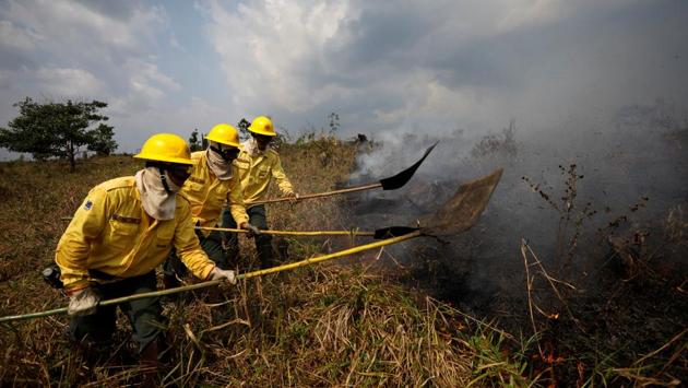 Brazilian Institute for the Environment and Renewable Natural Resources (IBAMA) fire brigade members attempt to control hot points during a fire in Apui, Amazonas state, Brazil. (Bruno Kelly / REUTERS) 