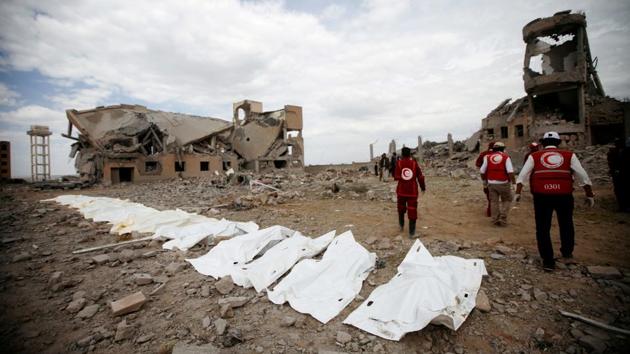 Red Crescent medics walk next to bags containing the bodies of victims of Saudi-led airstrikes on a Houthi detention centre in Dhamar, Yemen. (Mohamed al-Sayaghi / REUTERS) 