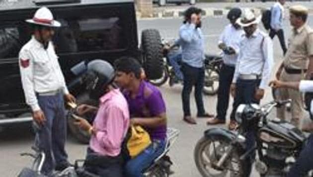 Traffic police personnel issue challans to traffic rules violators at Maharana Pratap Chowk, in Gurugram (HT Photo) Traffic police personnel issue challans to traffic rules violators at Maharana Pratap Chowk, in Gurugram (HT Photo)