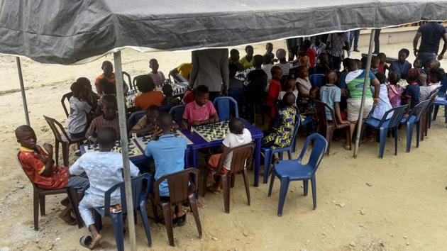 Children sit under a canopy as they play during a chess class. One 11-year-old boy even got a mentorship from a leading Nigerian architect after he was seen building models out of cardboard. “At first it was about teaching the kids a game that can impact the way they think and boost their confidence, but actually it’s become much more. It’s become a gateway to other opportunities,” says Onakoya. “It is helping us show them that their lives can go far beyond Ikorodu.” (Pius Utomi Ekpei/ AFP) Children sit under a canopy as they play during a chess class. One 11-year-old boy even got a mentorship from a leading Nigerian architect after he was seen building models out of cardboard. “At first it was about teaching the kids a game that can impact the way they think and boost their confidence, but actually it’s become much more. It’s become a gateway to other opportunities,” says Onakoya. “It is helping us show them that their lives can go far beyond Ikorodu.” (Pius Utomi Ekpei/ AFP)