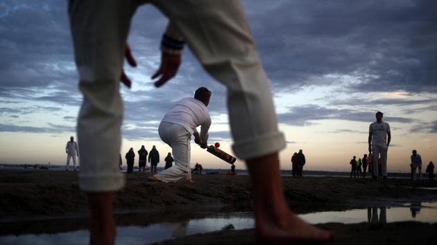 Players participate in the annual Brambles Sandbank cricket match at low tide in the Solent, England. (Hannah McKay / REUTERS) 