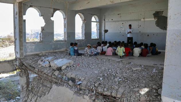 Children attend class on the first day of the new academic year, at a school that was damaged last year in an air strike during fighting between the Saudi-backed government forces and the Huthi rebels, in Yemen’s third-city of Taez. (Ahmad Al-Basha / AFP) 