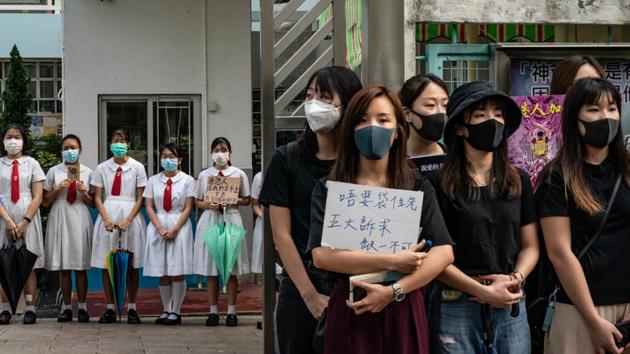 Students and alumni of Kit Sam Lam Bing Yim Secondary School form a human chain during a protest  in Hong Kong. Pro-democracy protesters have continued rallies on the streets despite Hong Kong’s leader Carrie Lam meeting a key demand of fully withdrawing the loathed extradition bill this week. (Anthony Kwan / Getty Images) 