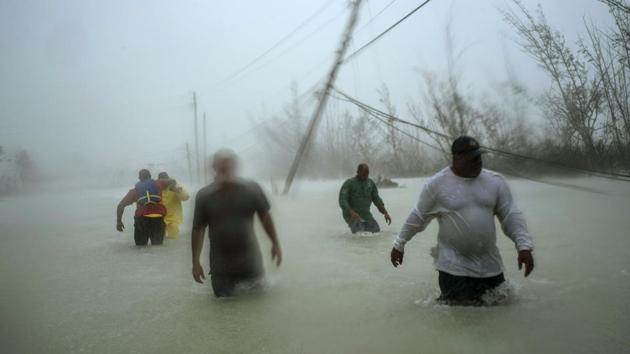 Volunteers wade through a flooded road against wind and rain caused by Hurricane Dorian to rescue families near the Causarina bridge in Freeport, Grand Bahama, Bahamas. The storm's punishing winds and muddy brown floodwaters devastated thousands of homes, crippled hospitals and trapped people in attics. (AP) Volunteers wade through a flooded road against wind and rain caused by Hurricane Dorian to rescue families near the Causarina bridge in Freeport, Grand Bahama, Bahamas. The storm's punishing winds and muddy brown floodwaters devastated thousands of homes, crippled hospitals and trapped people in attics. (AP)