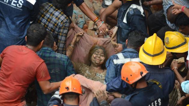 Ahmedabad Fire and Emergency services personnel rescue a woman after a residential building collapsed in Ahmedabad, Gujarat. (Sam Panthaky / AFP) Ahmedabad Fire and Emergency services personnel rescue a woman after a residential building collapsed in Ahmedabad, Gujarat. (Sam Panthaky / AFP)