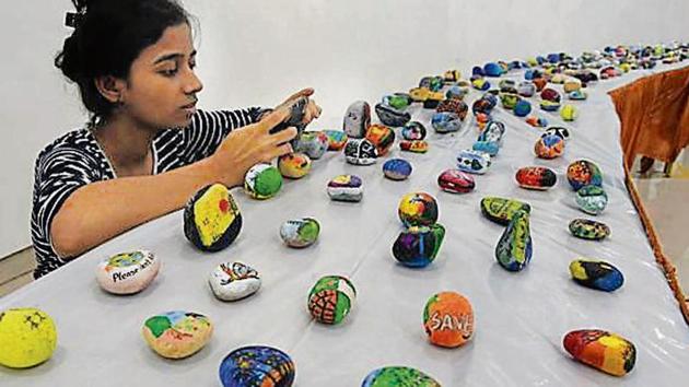 Stone paintings with awareness messages painted on them were given out as gifts at the exhibition.(praful gangurde/HT)