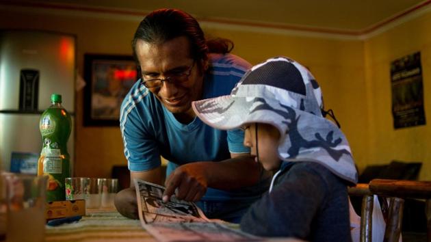 Isaac Callizaya and his son read comics at his home in El Alto city, Bolivia. Callizaya, 39, grew up with the sound of waves lapping the shores of Lake Titicaca. “When I was a child in the nineties, all families on the island lived off fishing. Today only three families are fishing, catching just some 20 fishes per day,” Callizaya said.” Before the year 2000 there were around 50 students at primary level. This year we only have one.” (Manuel Seoane / REUTERS) Isaac Callizaya and his son read comics at his home in El Alto city, Bolivia. Callizaya, 39, grew up with the sound of waves lapping the shores of Lake Titicaca. “When I was a child in the nineties, all families on the island lived off fishing. Today only three families are fishing, catching just some 20 fishes per day,” Callizaya said.” Before the year 2000 there were around 50 students at primary level. This year we only have one.” (Manuel Seoane / REUTERS)