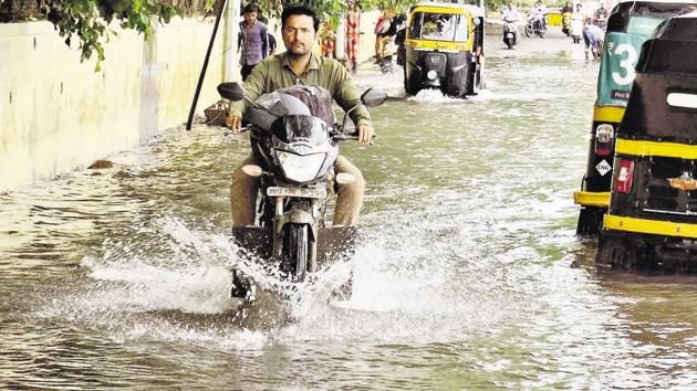 Commuters take the risk of driving their vehicles on a road stretch submerged under river water near Tilak bridge. (Ravindra Joshi/HT PHOTO) Commuters take the risk of driving their vehicles on a road stretch submerged under river water near Tilak bridge. (Ravindra Joshi/HT PHOTO)