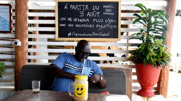 A customer sits on a couch in front of a glass with a metallic straw at the in Copacabana restaurant. President Macky Sall, sworn in for his second term in April, has proposed turning Senegal into a “zero waste” nation. Untreated effluent goes straight into the ocean and plastic debris is a chronic problem, often covering shorelines as far as the eye can see. (Seyllou / AFP)