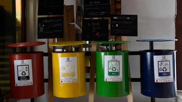 Recycling bins of different colours hang on a wall to raise awareness among customers at the Copacabana restaurant. On Yoff beach, dozens of children play amid the waste floating on the surf. (Seyllou / AFP)