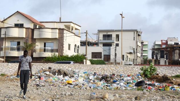 A man walks next to waste products on Yoff Virage beach, facing the Copacabana restaurant. Thiaw’s concerns were stirred a decade ago while surfing Atlantic waves on Yoff beach alongside dozens of plastic bottles. “On this beach, you can’t put a foot in the water without snagging a plastic bag,” he complains. (Seyllou / AFP)