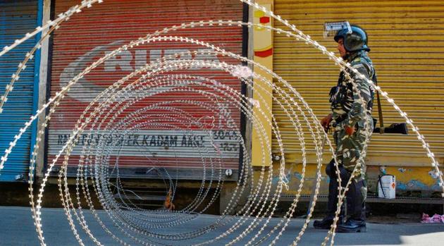 A security person stands guard at a blocked road during restrictions, after the abrogration of Article of 370 and bifurcation of state, in Srinagar, Monday, Sept. 9, 2019.(PTI file photo)