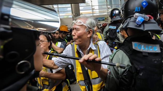 “Grandpa Wong” (C), 85, shields protesters from the police by holding his walking stick up along with other “silver hair” volunteers in the Tung Chung district in Hong Kong. “I’d rather they kill the elderly than hit the youngsters,” he told AFP during a recent series of skirmishes in the shopping district of Causeway Bay, a gas mask dangling from his chin. (Vivek Prakash / AFP) “Grandpa Wong” (C), 85, shields protesters from the police by holding his walking stick up along with other “silver hair” volunteers in the Tung Chung district in Hong Kong. “I’d rather they kill the elderly than hit the youngsters,” he told AFP during a recent series of skirmishes in the shopping district of Causeway Bay, a gas mask dangling from his chin. (Vivek Prakash / AFP)