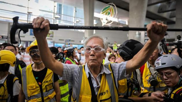 Grandpa Wong shields protesters by holding his walking stick up along with other “silver hair” volunteers. “It’s wrong to throw stones, that’s why the police beat them up,” he lamented. “I hope that police won’t hit them and the children won’t throw stuff back. Everyone should stay peaceful to protect the core values of Hong Kong.” (Vivek Prakash / AFP) Grandpa Wong shields protesters by holding his walking stick up along with other “silver hair” volunteers. “It’s wrong to throw stones, that’s why the police beat them up,” he lamented. “I hope that police won’t hit them and the children won’t throw stuff back. Everyone should stay peaceful to protect the core values of Hong Kong.” (Vivek Prakash / AFP)