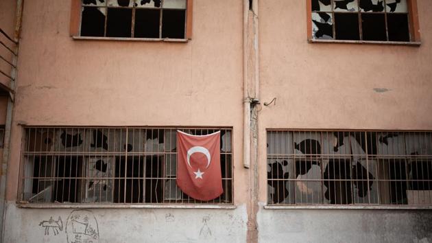 A Turkish flag hangs from the window of an abandoned factory in Hilal, one of the poorest areas in Izmir. In 2015, more than 800,000 mainly Syrian and Afghan migrants took to the seas off Turkey to make the short but perilous trip to Greece. The numbers fell dramatically the next year after a deal between the European Union and Turkey to stem the exodus. (Ekaterina Anchevskaya / REUTERS) 