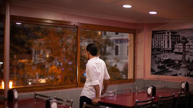 Ahmed looks out from a window in a Syrian restaurant popular among refugees in Izmir. “Maybe these are signs that we should not go,” Ahmed would sometimes say in the lead-up to their 2018 attempt. “Every new problem is trying to say something to us.” But he saw no option but to leave Turkey, because staying meant he would “keep working in that factory forever”. (Ekaterina Anchevskaya / REUTERS) 