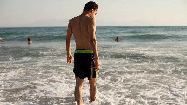 Ahmed walks into the water for his first swim in the Aegean Sea. The family says they can try again with the same smuggler, for no extra fee, though Ahmed is despondent as he watches the clouds gathering above the darkening waters. “I never felt worse,” he says. “So much thinking, and a storm is coming.” (Ekaterina Anchevskaya / REUTERS) 