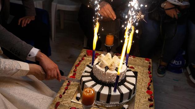 Ahmed and Hanin cut the cake on their wedding night in Izmir. They were quickly swept up in a flurry of wedding preparations: searching for the perfect dress, struggling to wire money across Western Union offices, planning a two-night party. (Ekaterina Anchevskaya / REUTERS) 