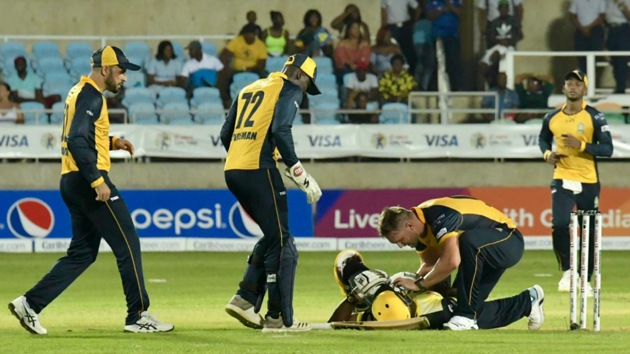 Andre Russell falls on the ground as opposition players come in to check.(@JAMTallawahs)