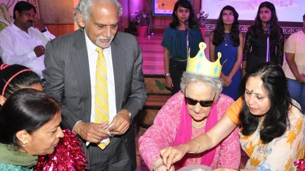 The chairperson and the principal cut the cake as the children sang(The)